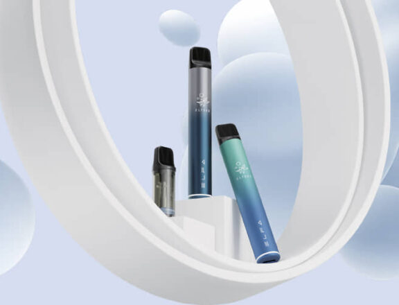 Zwei ELFBAR ELFA Bars und ein ELFBAR ELFA PODsind unterschiedlich auf einem Podest. Die Farben der Akkus sin jeweilsblau-Silber und blau-türkise. Der Hintergrund ist hellblau- weiß mit formationen wie in einer Lavalampe.